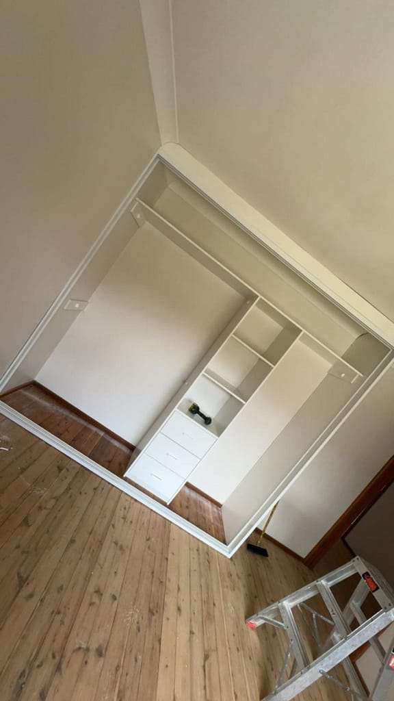 Professional wardrobe installation team assembling custom cabinetry on-site